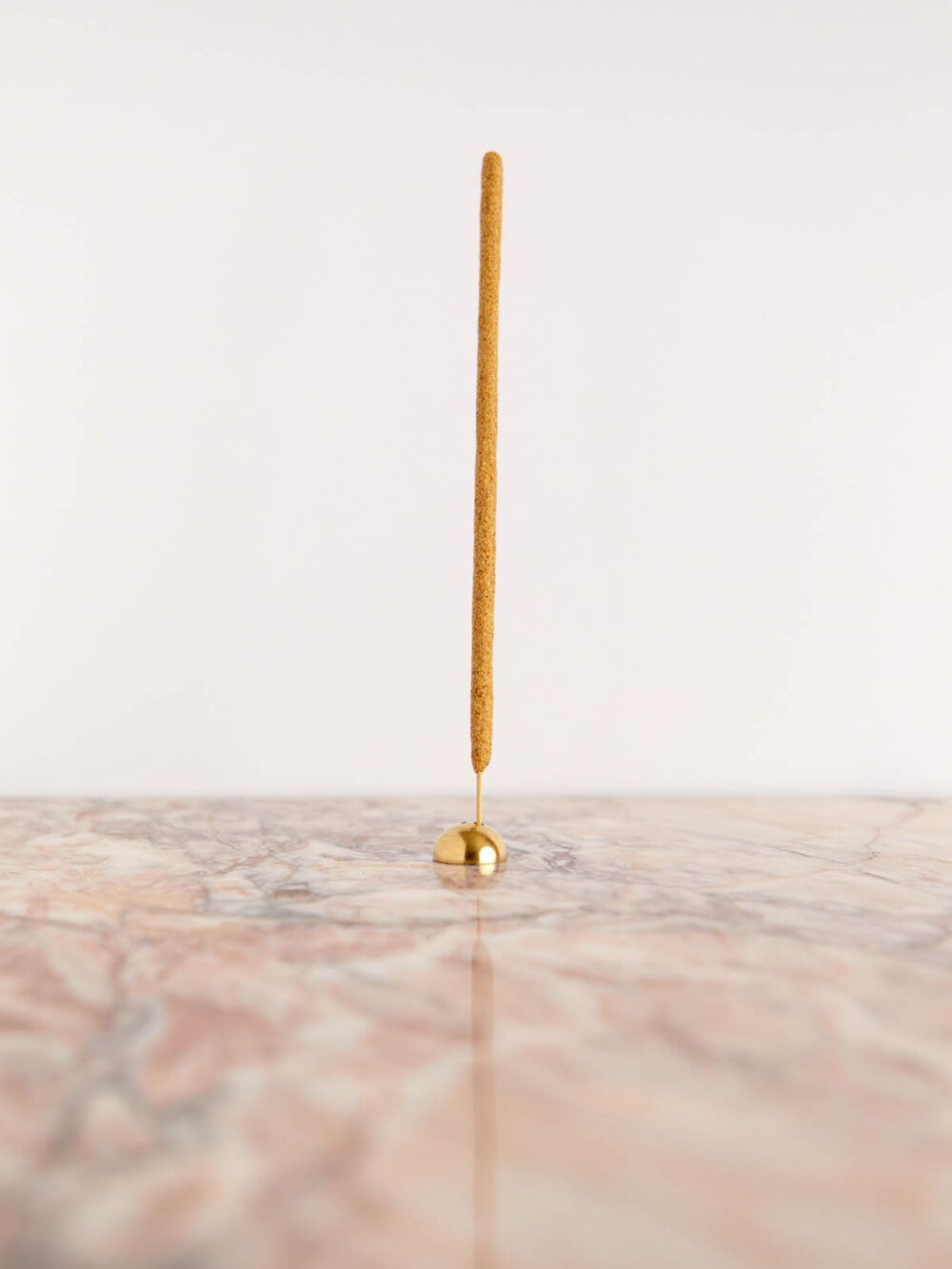 Brass Arch Incense Holder by Cedar & Myrrh with incense on pink marble