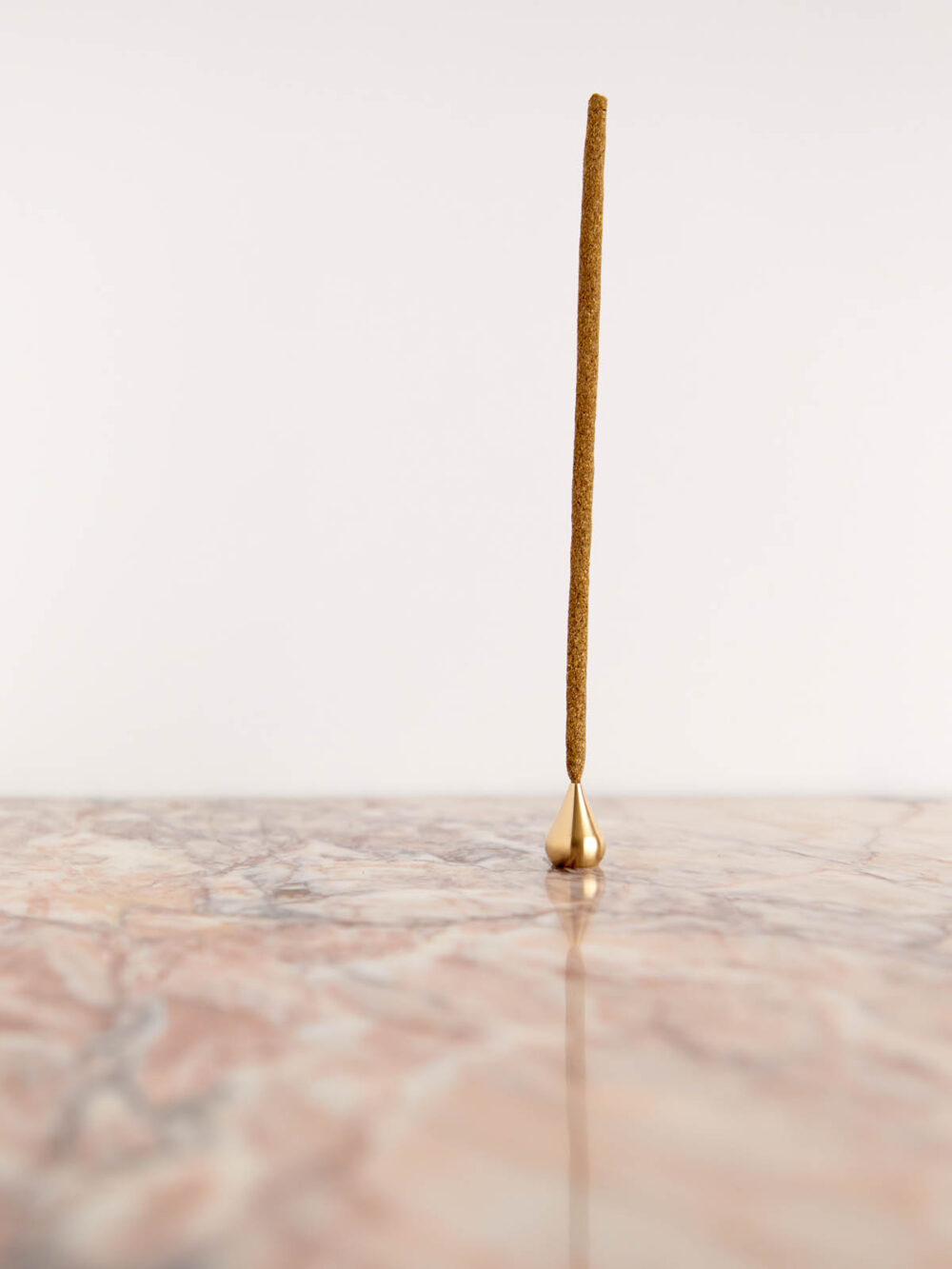 Tall Brass Water Drop Incense Holder by Cedar & Myrrh with incense on pink marble