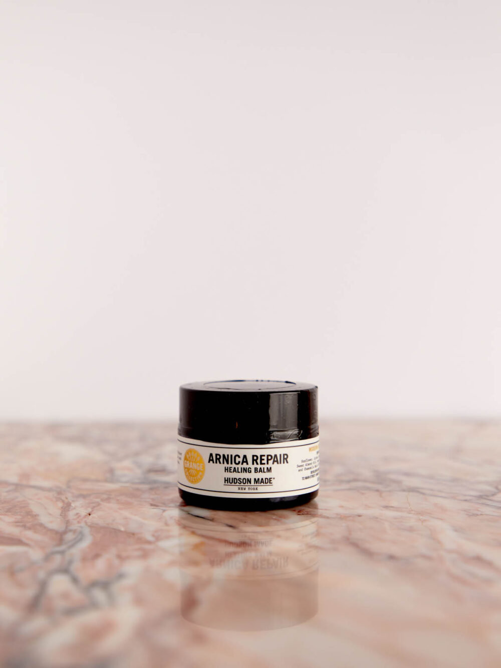 Arnica Repair Cream on pink marble by Hudson Made