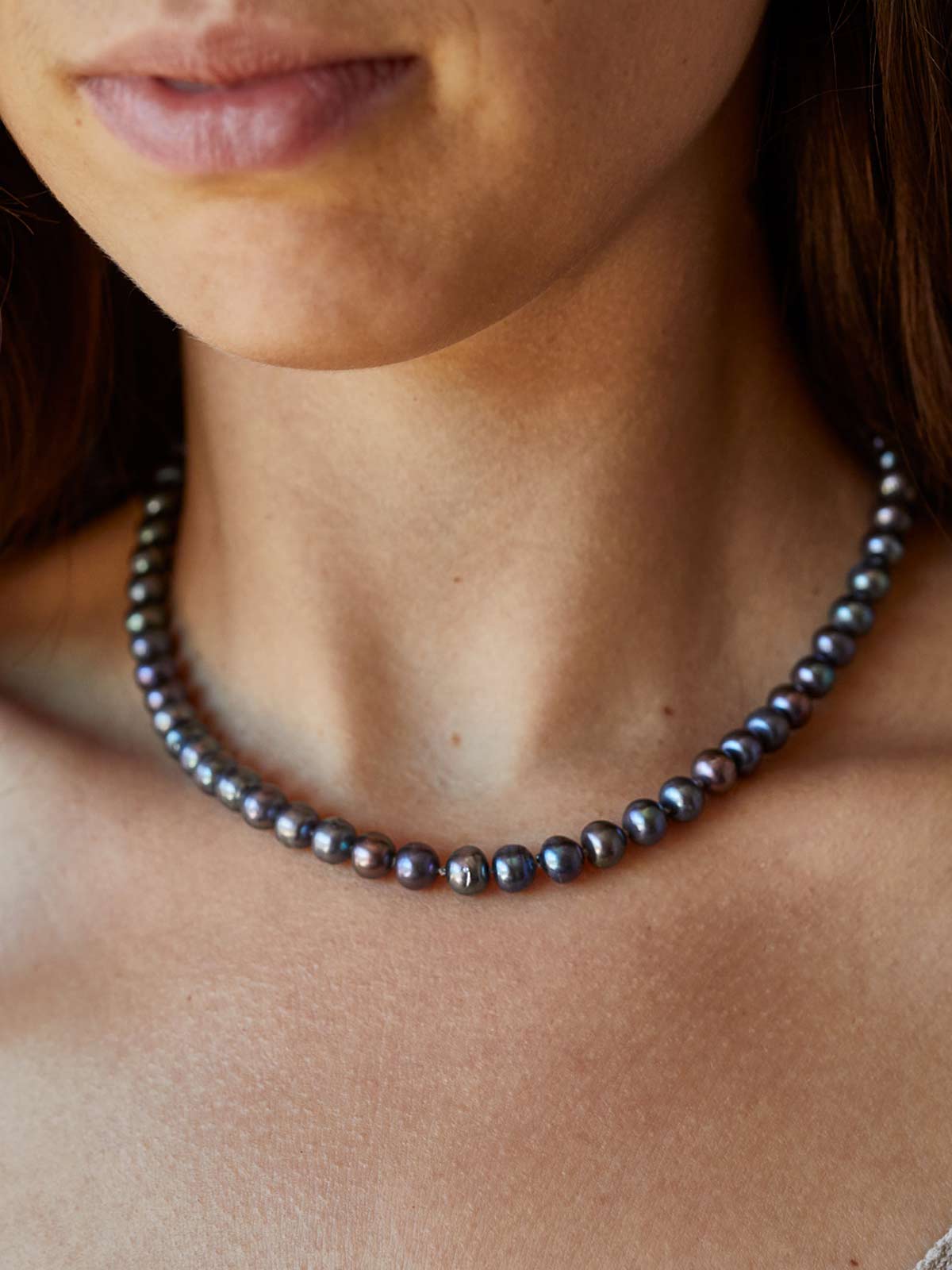black pearl necklace on a woman's neck