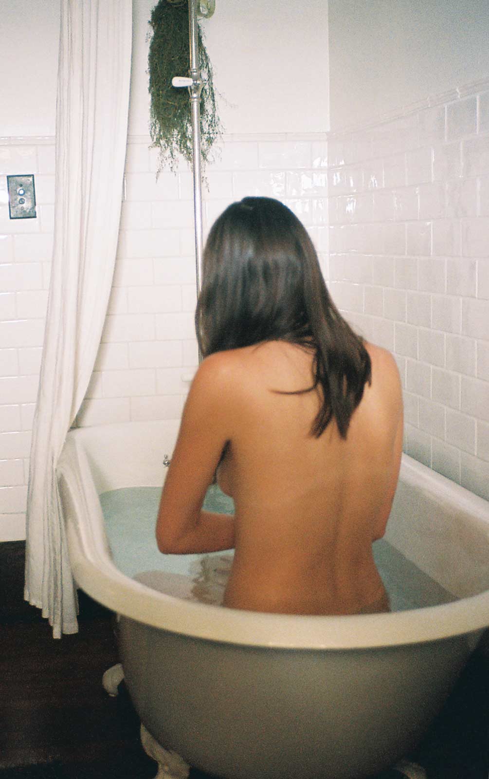 dark-haired woman in clawfoot tub