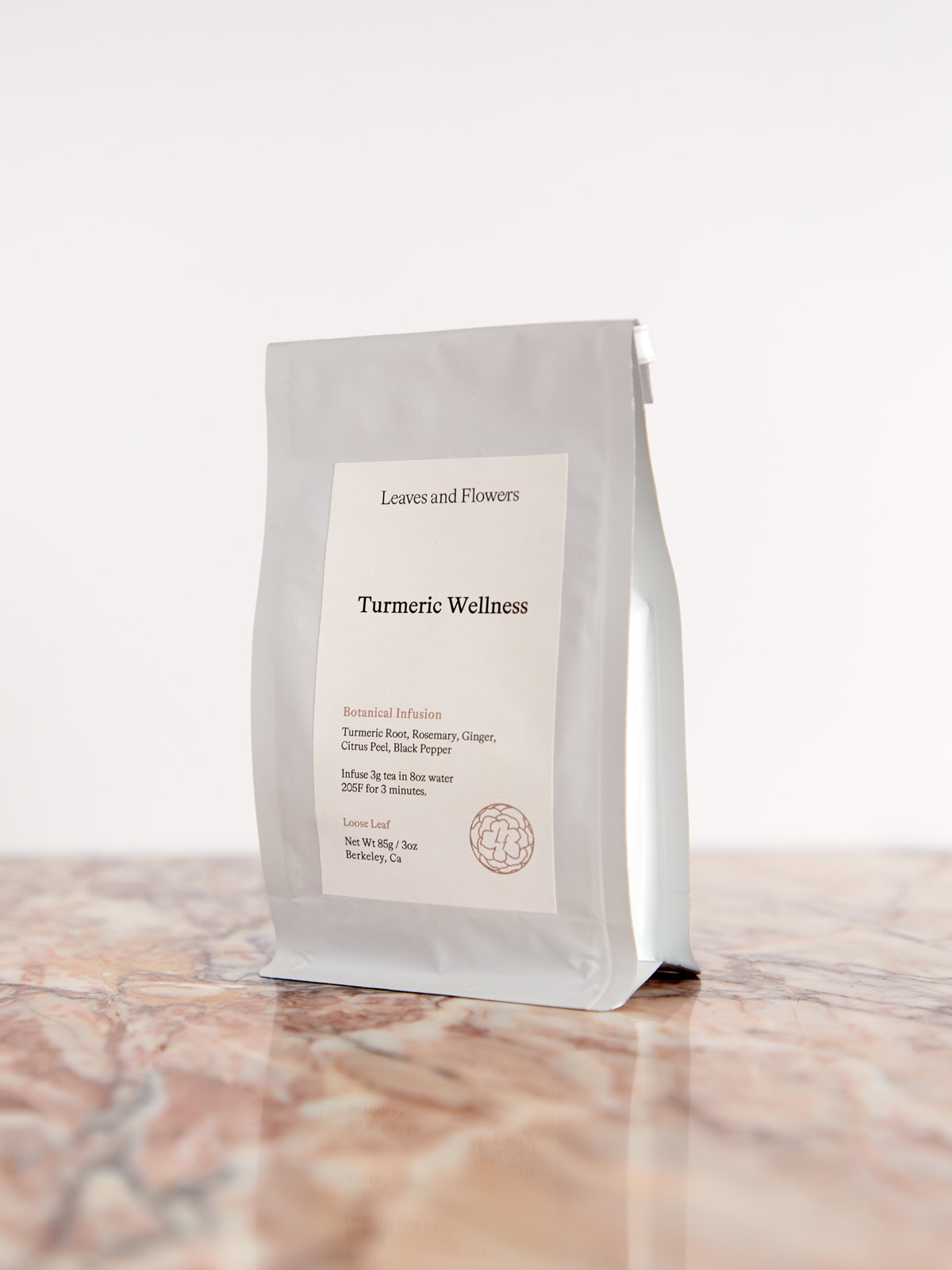 Turmeric Wellness Tea by Leaves & Flowers package on pink marble