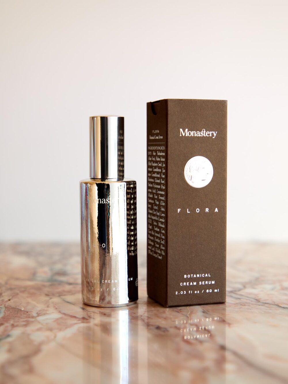 Flora Botanical Cream Serum and box on pink marble by Monastery Made