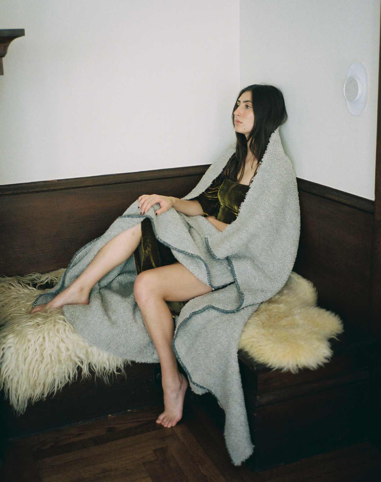 woman wrapped in a luxurious grey blanket